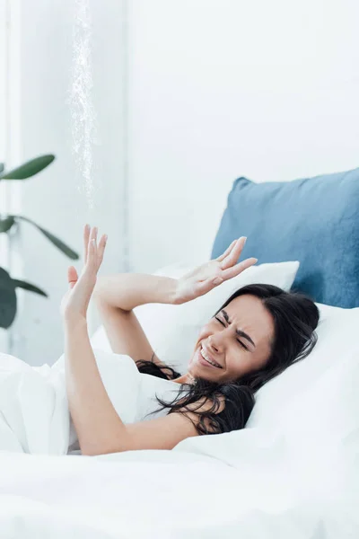Стрессовая женщина в постели разбирается с повреждениями воды — стоковое фото