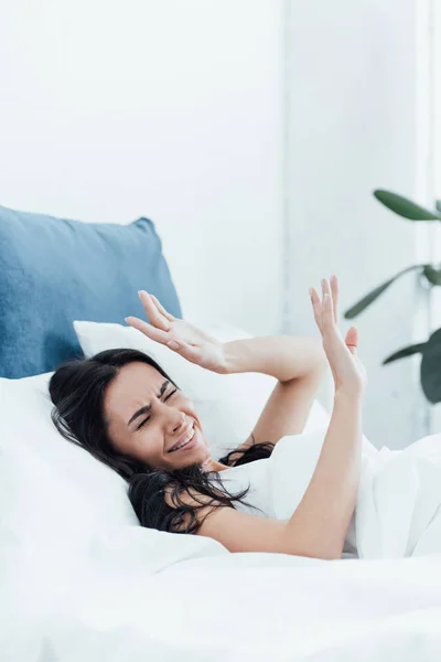 Gereizte brünette Frau liegt mit geschlossenen Augen im Bett — Stockfoto