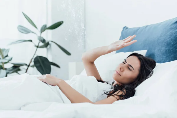 Mulher irritada deitada na cama sob o teto vazando — Fotografia de Stock