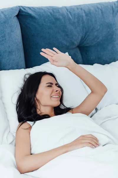 Unzufriedene brünette Frau liegt mit geschlossenen Augen im Bett — Stockfoto