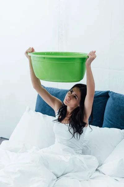 Mulher perturbada usando bacia durante vazamento no quarto — Fotografia de Stock