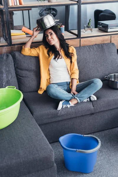 Funny young woman holding pot above head — Stock Photo