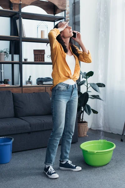 Mulher cansada em jeans falando ao telefone na sala de estar — Fotografia de Stock