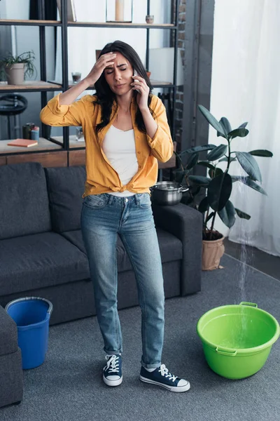 Втомилася жінка торкається чола під час розмови по телефону — стокове фото
