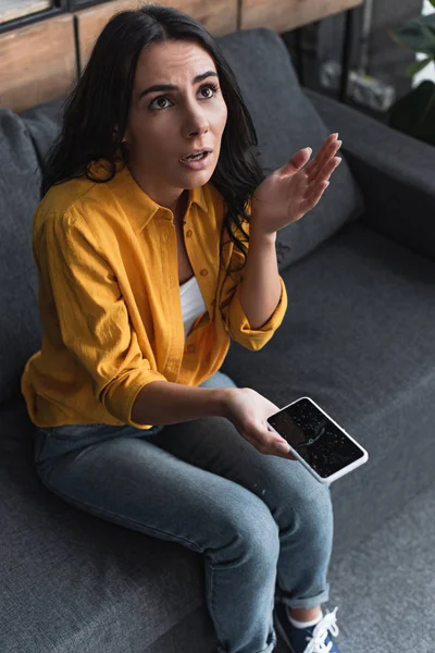 Femme bouleversée avec smartphone endommagé par l'eau regardant vers le haut — Photo de stock