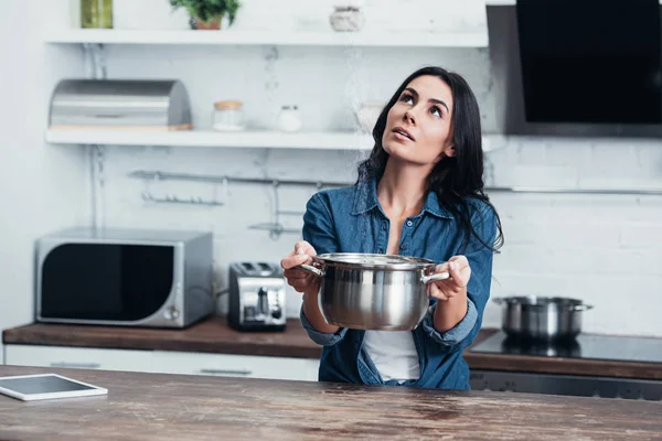 Ragazza curiosa in possesso di pentola d'acciaio e guardando verso l'alto — Foto stock