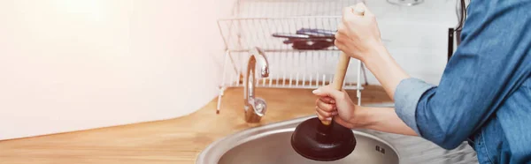 Cropped view of woman in denim shirt using plunger in sink — Stock Photo