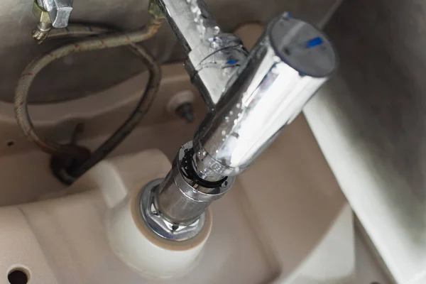 Fuites de tuyaux en acier sous l'évier avec des gouttes d'eau — Photo de stock