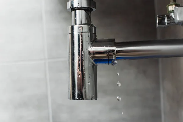 Tubo brillante de acero con gotas de agua sobre fondo gris - foto de stock