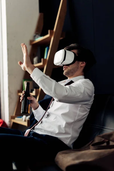 Homme portant casque de réalité virtuelle et tenant bouteille de bière — Photo de stock