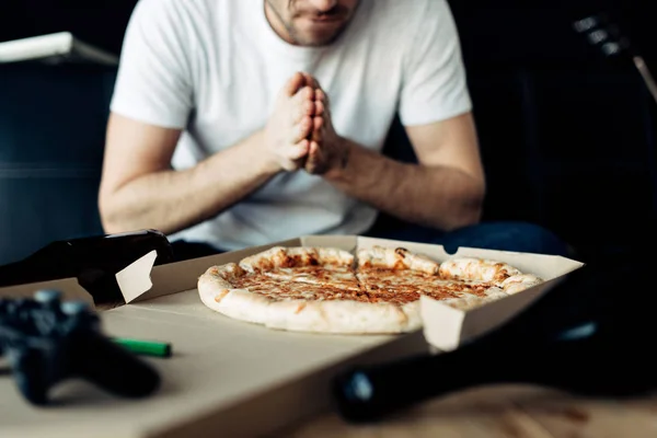 Abgeschnittene Ansicht eines Mannes, der sich zu Hause leckere Pizza anschaut — Stockfoto