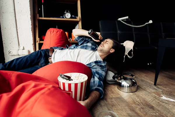 Somnolent homme ivre couché sur un sac de haricots et boire de la bière — Photo de stock