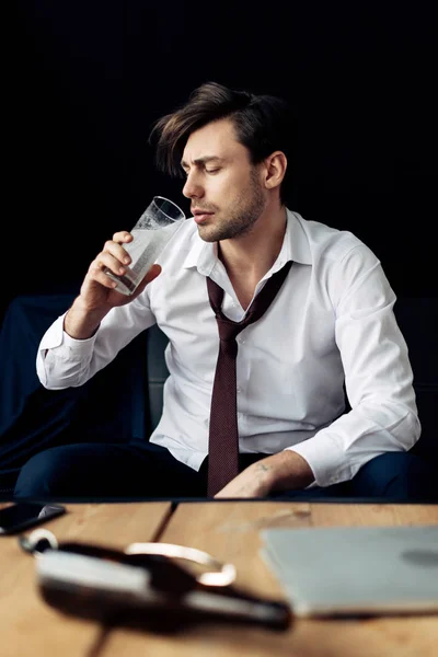 Handsome drunk man in suit drinking water after party — Stock Photo