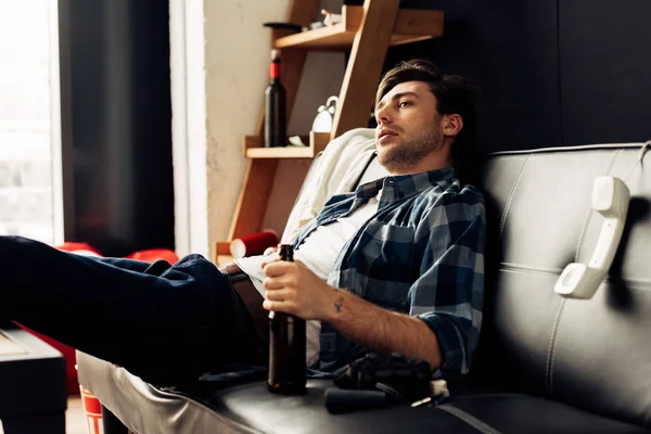 Handsome man holding bottle with beer in hand after party — Stock Photo