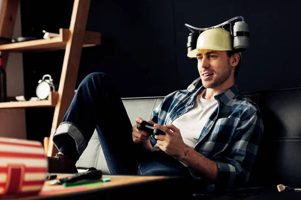 Homem feliz em capacete de cerveja jogando videogame em casa — Fotografia de Stock
