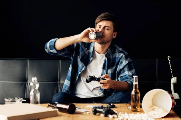 Bell'uomo che beve birra e gioca a videogiochi a casa — Foto stock