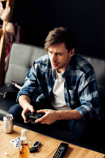 Bel homme jouant à un jeu vidéo à la maison — Photo de stock