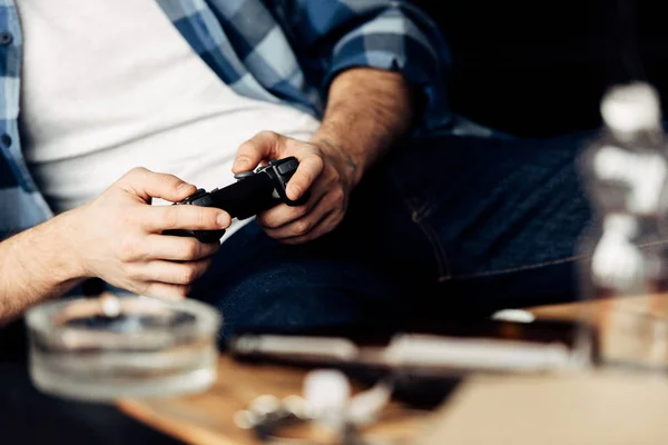 Abgeschnittene Ansicht eines Mannes, der zu Hause Videospiele spielt — Stockfoto