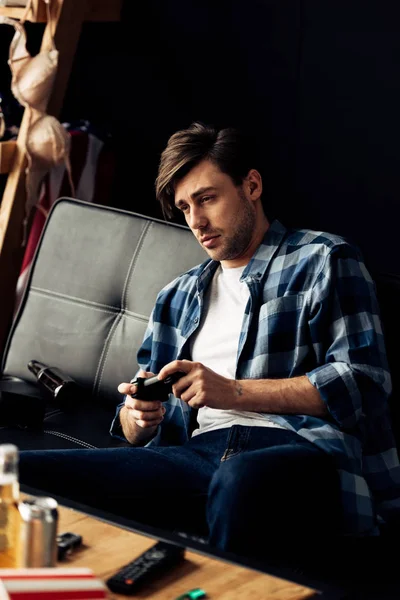 Виснажений чоловік грає у відеоігри у вітальні — стокове фото