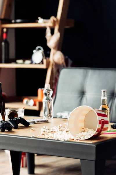 Selective focus of popcorn near bottles with beer on coffee table — Stock Photo