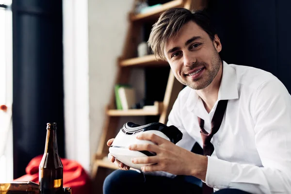 Cheerful man holding virtual reality headset after party — Stock Photo