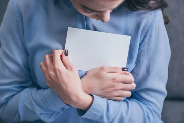 Cropped view of woman in blue blouse holding and hugging photo in room, grieving disorder concept — Stock Photo