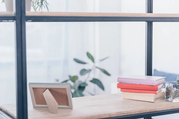 Selective focus of photo frame and books on wooden rack — Stock Photo