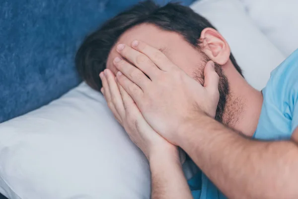 Homem de luto na cama cobrindo rosto com as mãos e chorando em casa — Fotografia de Stock