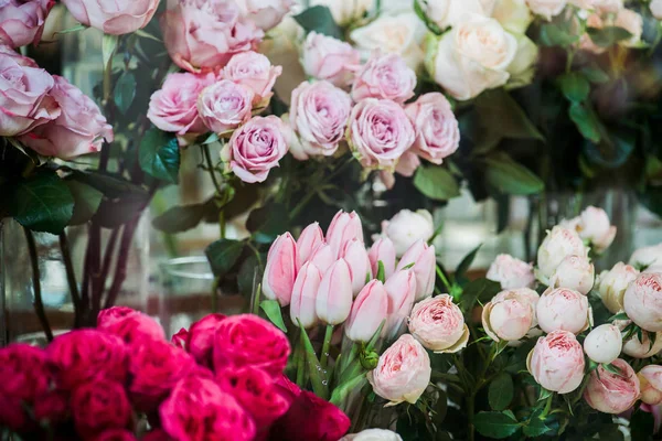 Variedad de coloridas rosas y tulipanes florecientes - foto de stock