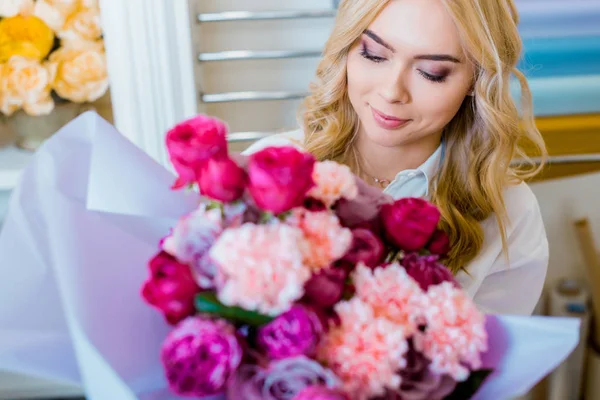 Bella donna che tiene mazzo di fiori con rose e garofani — Foto stock