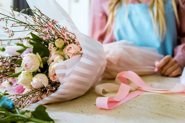Частковий вид на жіночого флориста, який влаштовує свіжий квітковий букет з трояндами — стокове фото