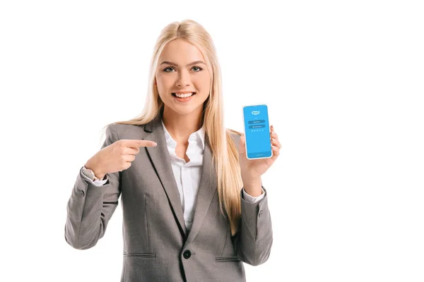 Sonriente mujer de negocios apuntando al teléfono inteligente con aplicación skype, aislado en blanco - foto de stock