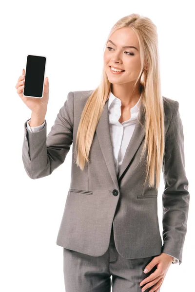 Усміхнена бізнес-леді, що показує смартфон з порожнім екраном, ізольовано на білому — стокове фото