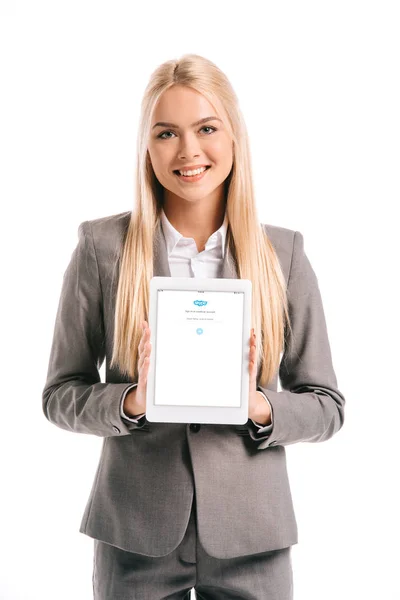Усміхаючись блондинка бізнес-леді показ цифровий планшет з skype прилад на екрані, ізольовані на білому — стокове фото