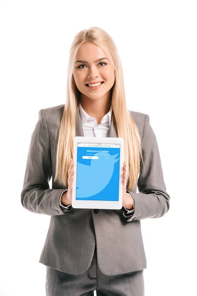 Heureuse femme d'affaires blonde montrant tablette numérique avec application twitter à l'écran, isolé sur blanc — Photo de stock