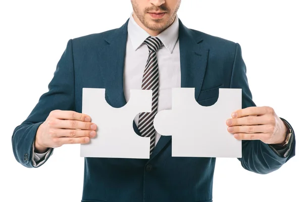 Vista recortada de hombre de negocios sosteniendo piezas de rompecabezas aislados en blanco, concepto de solución de negocio - foto de stock