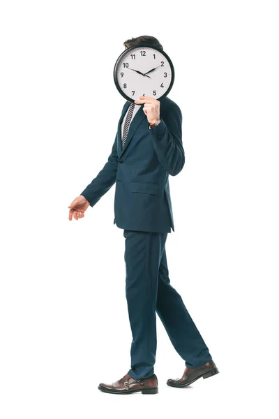 Businessman in suit holding clock in front of the face while walking isolated on white — Stock Photo