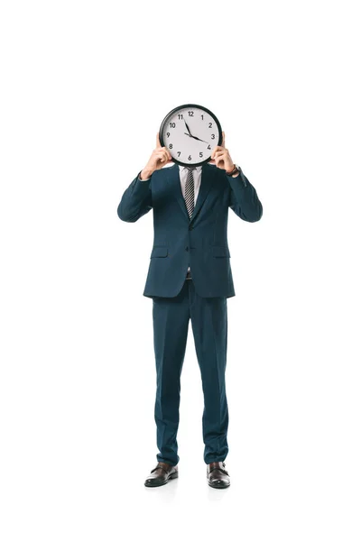 Businessman in formal wear holding clock in front of the face, isolated on white — Stock Photo