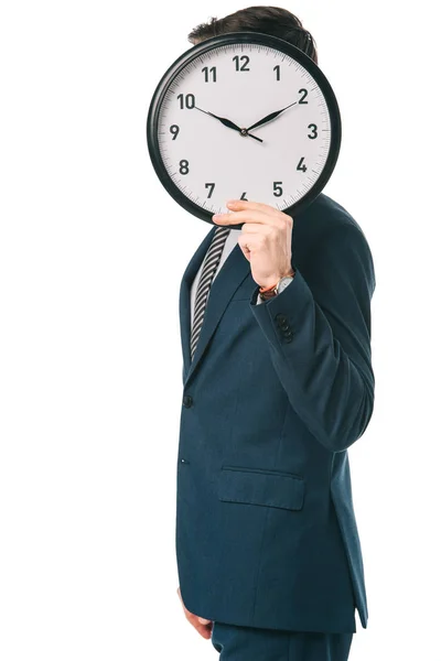 Hombre de negocios sosteniendo el reloj en frente de la cara, aislado en blanco - foto de stock