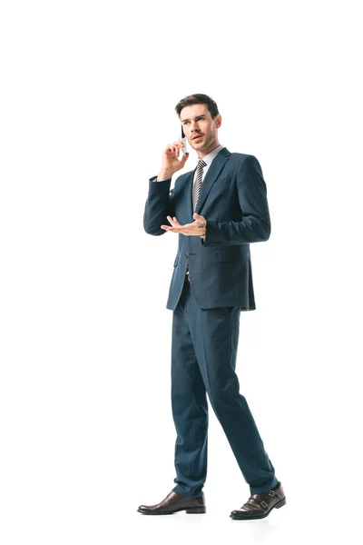 Confuso hombre de negocios en traje hablando en teléfono inteligente aislado en blanco - foto de stock