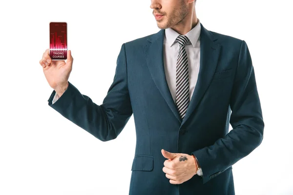 Vista recortada de hombre de negocios mostrando teléfono inteligente con aplicación cursos de comercio, aislado en blanco - foto de stock