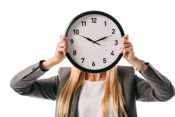 Mujer de negocios sosteniendo el reloj en frente de la cara, aislado en blanco - foto de stock