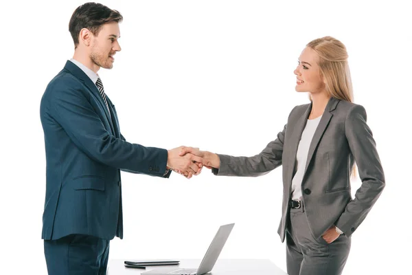 Executive businesspeople shaking hands and having deal at workplace with laptop, isolated on white — Stock Photo