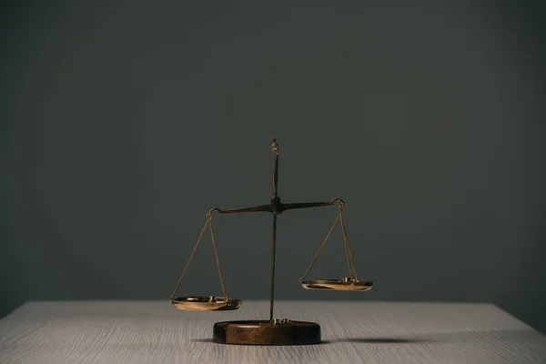 Empty scales of justice on wooden table on grey — Stock Photo