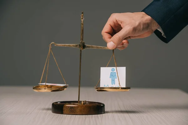 Visión recortada de empresario con escalas de justicia y signos masculinos, concepto de estereotipos de género - foto de stock