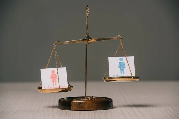 Male and female signs on scales on wooden table, gender equality concept — Stock Photo