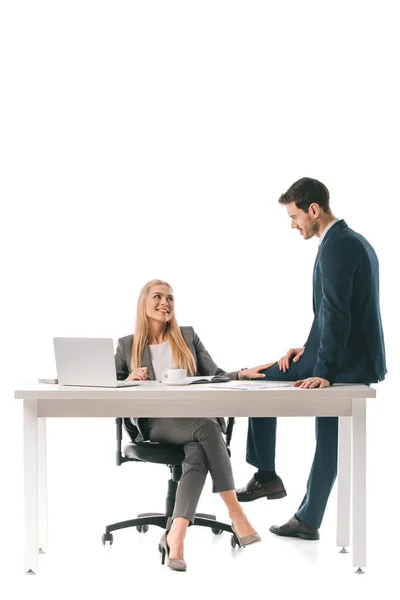 Beautiful smiling businesswoman flirting with male colleague at workplace with laptop — Stock Photo