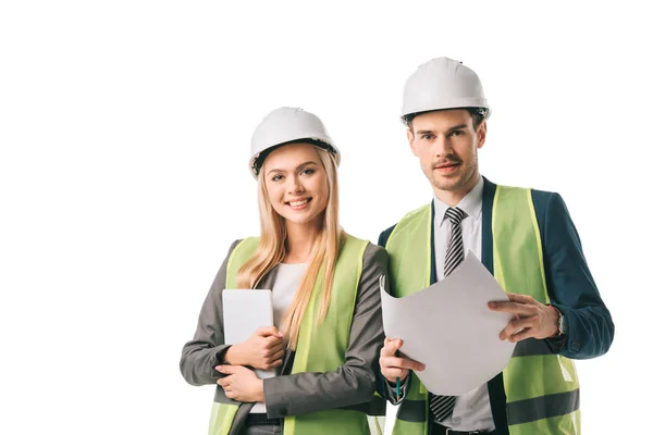 Engineers in safety vests and hardhats holding digital tablet and blueprint, isolated on white — Stock Photo