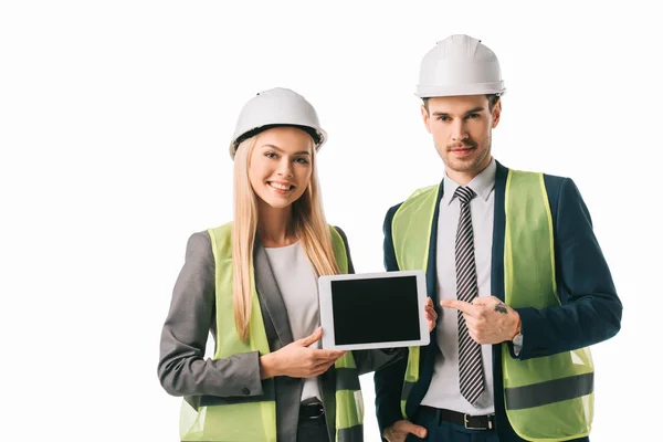 Architetti in giubbotti di sicurezza e hardhat mostrando nuovo progetto su tablet digitale, isolato su bianco — Foto stock