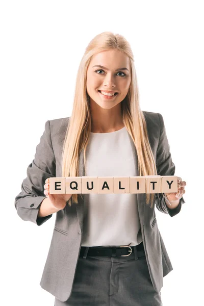 Smiling businesswoman in sign holding alphabet cubes with equality word, isolated on white — Stock Photo